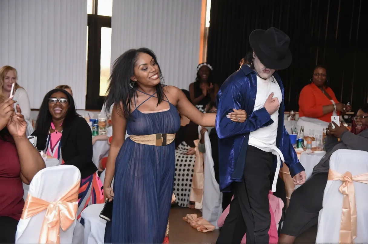 Michael Jackson impersonator MJ3 escorts a smiling guest during a performance finale at a wedding in Atlanta